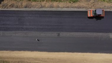 Yol paten makinesi asfalt yuvarlar. Yeni yol inşaatında çalışan yol silindirlerinin hava manzarası
