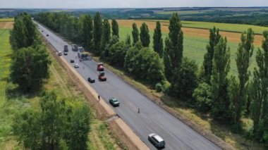 Yol yapım ekipmanları. Asfalt kaldırım taşı, paten ve kamyon asfaltlama sırasında yol onarım alanında
