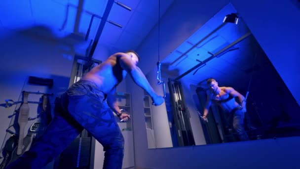 ジムで働いてる男 鏡の前で体操の練習を後押しするためにハンサムなボディビルダーが動作します — ストック動画