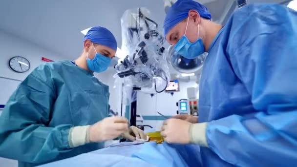 外科手術を行うチーム 滅菌装置を用いて手術を行う防護服を着た医師 — ストック動画