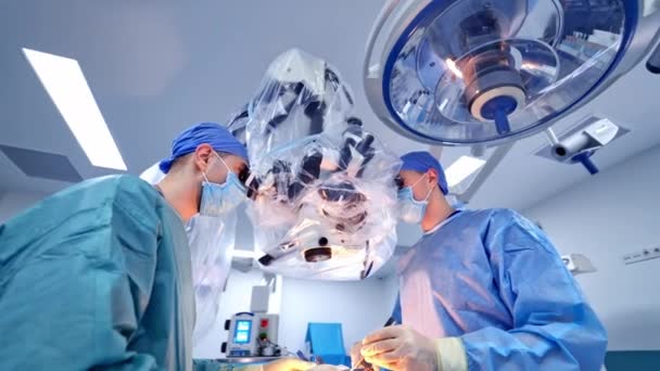 進行中の手術室 明るい近代的な手術室で外科手術を行う医療チーム — ストック動画