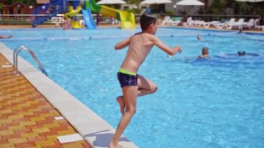 Bilardodaki mutlu çocuk. Açık havuza atlayan aktif bir genç çocuk.