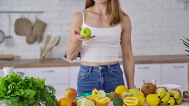果物と女性の台所の肖像画 キッチンに立つ魅力的なアスレチックスポーツ女性 — ストック動画