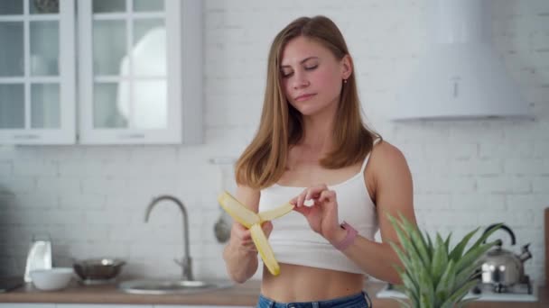 台所の若い女性 健康食品を食べる若いスポーティーな女性の肖像画 — ストック動画