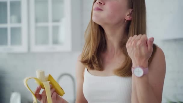 オーガニック ブレックファーストを食べる女性 バナナを食べる若い幸せな女性のライフスタイルの肖像 — ストック動画