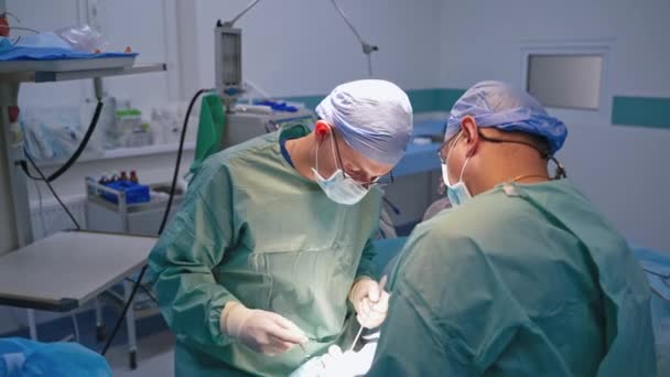 手術中の外科医 手術室で働く外科医のグループ — ストック動画