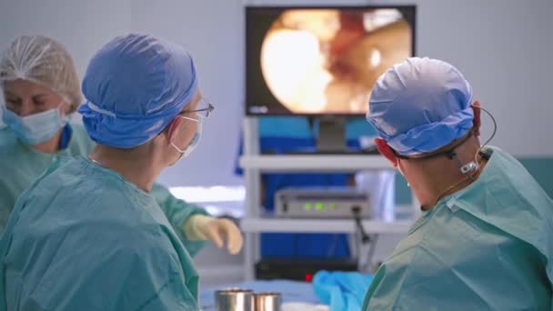 Chirurgen Opereren Patiënt Achteraanzicht Van Chirurgen Team Kijkt Naar Monitoren — Stockvideo