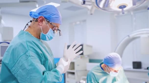 手術室で働いているチーム外科医 彼のチームと手術室の男性医師 — ストック動画