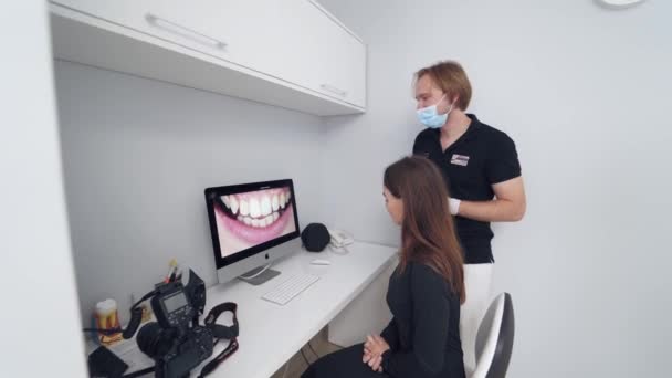 Kvinnan Tittar Tänderna Snygg Tandläkare Visar Patienten Tänderna Datorn — Stockvideo