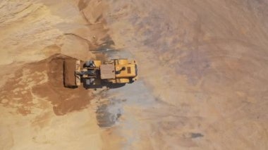 Yol yapım aşamasında. İnşaat alanında çalışan ağır makinenin üst görünümü