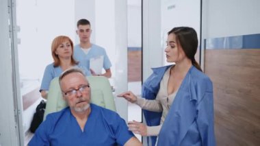 Hastanenin koridorundaki hasta. Hastanede tekerlekli sandalyedeki yaşlı hastayla ilgilenen aileler.