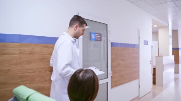 Patient Rollstuhl Mit Arzt Frau Rollstuhl Mit Professionellem Pflegepersonal Krankenhausflur — Stockvideo