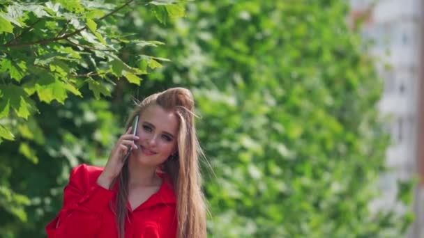 年轻女人用智能手机 一个迷人的微笑女孩用智能手机说话的画像 — 图库视频影像