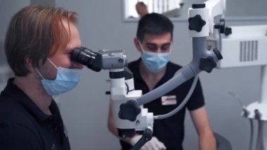 Modern ekipman mikroskobu dişçi ofisinde. Doktor dişçi modern diş muayenehanesinde diş mikroskobu kullanıyor.