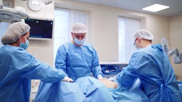 外科医療チームが室内で活動しています 病院の外科医の医療チームは 侵襲的外科的介入を最小限に抑える — ストック動画
