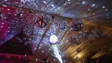 Parlayan topların gümüş ışığı. Gece kulübünün tavanından parlayan disko topu. Kutlama konsepti.