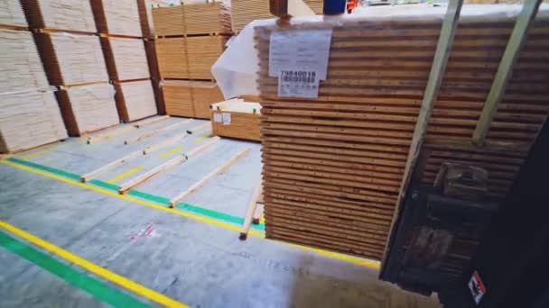 木の生産について フォークリフトは倉庫を通って木製の板を運ぶ ワークショップ内のトラックに移動する木製パネルの打ち上げ — ストック動画
