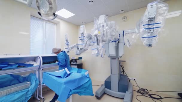 手術室のロボット装置 看護師は現代的な手術室で働いています クリニックの医療ロボット 病院のハイテク機器 — ストック動画