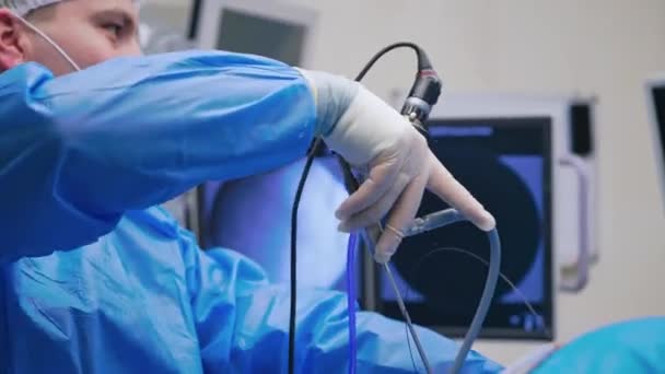 新しい医療機器を持った医師 医療用ユニフォームのスペシャリストは 手術中に現代的な楽器を使用しています クローズアップ — ストック動画
