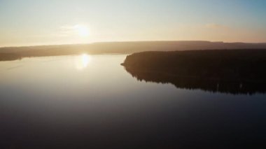 Nehirde gün batımının güzel manzarası. Akşam nehrinin sinematik görüntüleri. Güneş doğada batıyor. Hava görünümü.