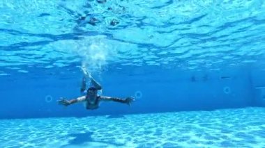 Havuzun içine dalan yakışıklı bir adam. Yüzme havuzunun berrak sularında yüzen bir adam. Sağlıklı yaşam tarzı.