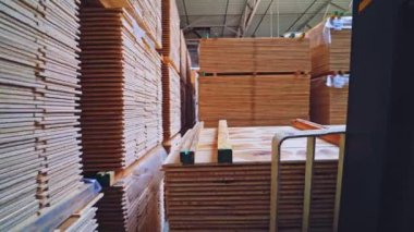 Fabrikanın döşemesi için tahta tahtalar. Forklift arabası depoya parke panel yığını koyuyor. Mobilya üretimi.