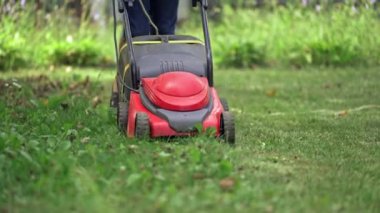 Genç çocuk yaz saati bir çim biçme makinesi ile çim kesme