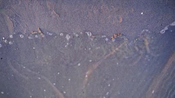 砂浜に手書きの絵が描かれています 水の波が砂にシンボルを壊し それを洗い流します トップビュー — ストック動画