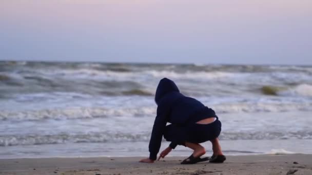 Junge Der Sich Bei Sonnenuntergang Meer Ausruht Kind Malt Sandstrand — Stockvideo