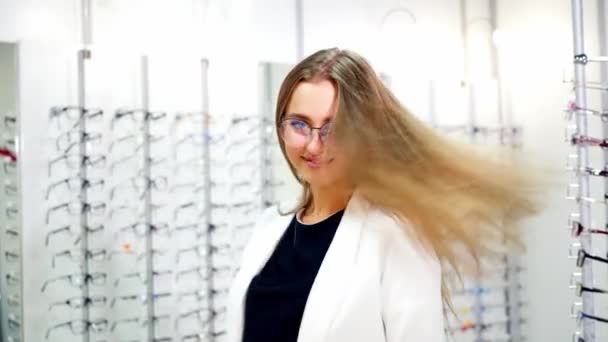 年轻女人检查她的新眼镜在光学 漂亮的微笑女孩 戴着眼镜 在镜头前摆姿势 — 图库视频影像