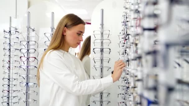可爱的女孩在商店里选择眼镜 迷人的年轻女人买时髦的眼镜 视觉和保健概念 — 图库视频影像