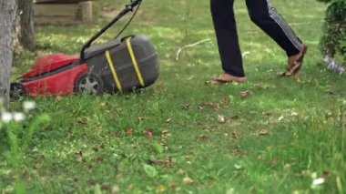 Çim biçme yakın çekim. Varoşlarda kadın biçme çim.