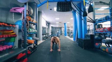 Spor salonundaki kaslı bir kadının ön görüntüsü. Fitness kızı vücudunu modern spor merkezinde eğitiyor. Günlük idman. Sağlıklı yaşam tarzı.