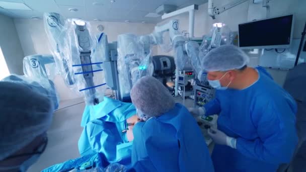 医師は操作前にロボット機器を準備する 医用ユニフォームの外科医は ロボットデバイスを使用して最小限の侵襲操作を実行します — ストック動画