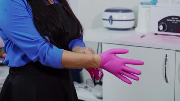 Schoonheidsspecialiste Doet Latex Handschoenen Aan Cosmetoloog Doet Roze Medische Handschoenen — Stockvideo