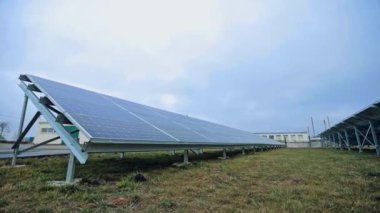 Mavi gökyüzünün altındaki çimlerde eko güneş pili var. Elektrikte yenilikçi bir teknoloji. Yenilenebilir enerji için fotovoltaik güneş panelleri.