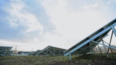 Yenilikçi güneş çiftliği. Yerde güneşli bataryaları olan metal yapılar. Fotovoltaik güneş panelleri alternatif enerji üretir. Aşağıdan görüntüle.