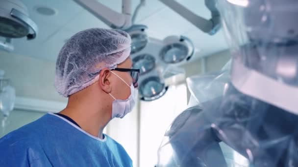 Ameliyathanede Bir Doktorun Yan Görüntüsü Klinikteki Modern Robotik Ekipman Yakınlarında — Stok video
