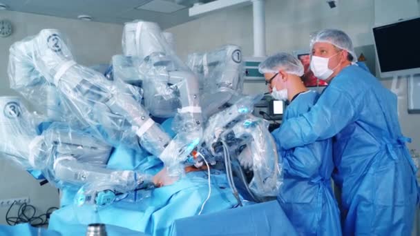 腹腔鏡操作中にロボットマシン 近代的な手術室で2人のスペシャリストが最小限侵襲手術を行います — ストック動画