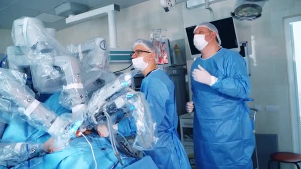 외과의사들은로봇기기의작업을통제합니다 클리닉의 수술실에서 현대적인 장비의 도움으로 복잡한 — 비디오
