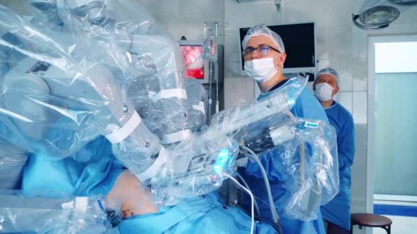 医師はロボット手術をコントロールする 患者に手術を行う現代の医療機器 手術における新しい技術 — ストック動画