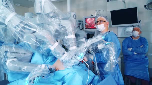클리닉에서 현대적인 의사는 장치를 사용하여 수술을 수행합니다 외과의사들은 모니터의 화면을 — 비디오