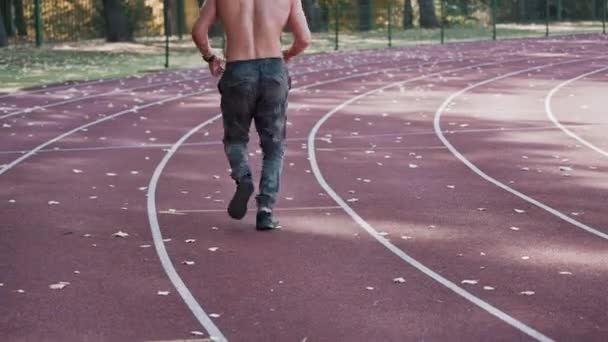 Widok Mężczyzny Biegającego Stadionie Młodzi Sportowcy Ćwiczą Bieganie Jesienią Torze — Wideo stockowe