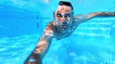 Su altı eğlencesi. Havuzda yüzen yakışıklı genç adam. Spor ve eğlence..