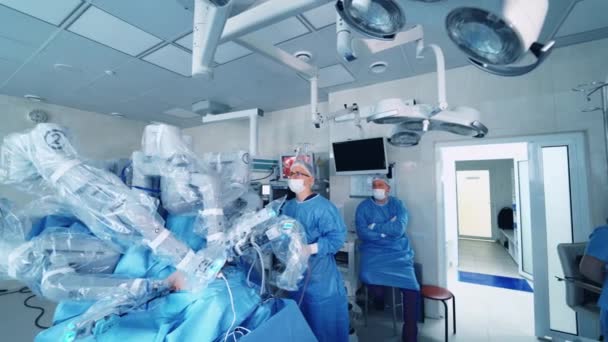 外科医のチームは 医療外科ロボットを使用して繊細な操作を行います 現代医療機器について 最小侵襲手術のためのロボットアーム — ストック動画