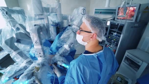 手術をする医療用外科ロボット 現代医療機器について 最小侵襲ロボット手術システムによる手術を行うスペシャリスト — ストック動画