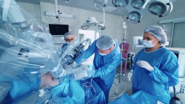手術室の外科医のグループ クリニックの近代医療ロボットシステム 手術で未来的な機械で働くスペシャリスト — ストック動画