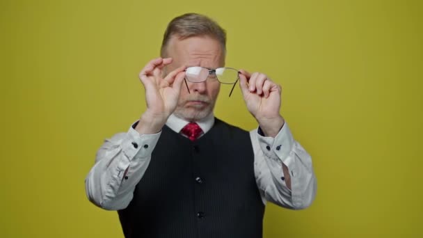 Starszy Pan Trzyma Nowe Okulary Odizolowane Żółtym Studio Dojrzały Mężczyzna — Wideo stockowe