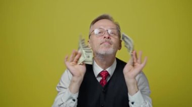 Mutlu kıdemli adam paradan hoşlanır. Elinde bir sürü banknot olan yaşlı bir işadamının portresi. Harika iş anlaşması..