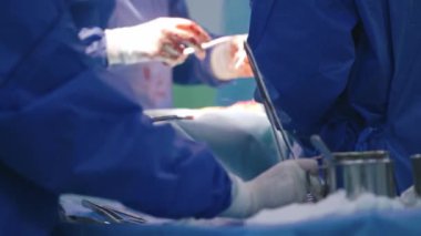 İşlem süreci. Ameliyat sırasında kandaki doktorların elleri. Tıbbi gereçler masada. Yakın plan..